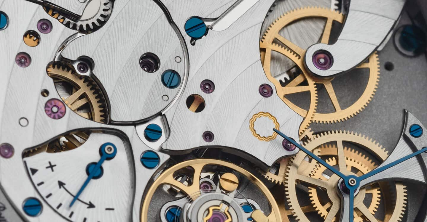 A detailed close-up of intricate mechanical components of a luxury timepiece movement.