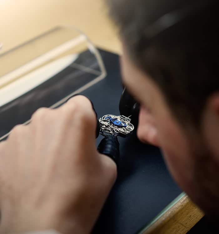 A detailed shot of a craftsman assembling a luxurious timepiece, showcasing intricate craftsmanship.