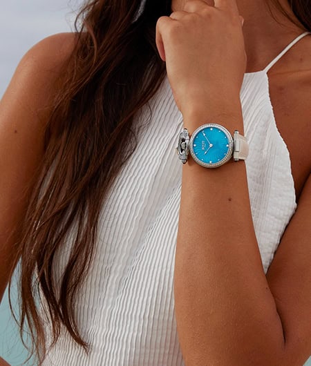 Elegant blue timepiece worn on woman's wrist, perfect for Fleurier - Miss Audrey collection.