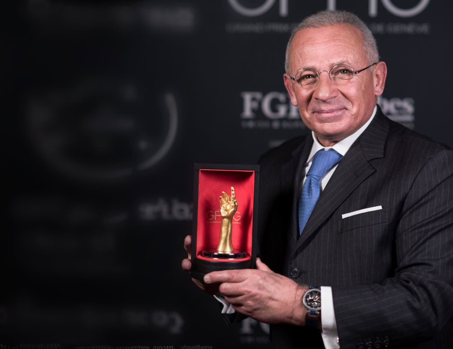 Elegant man holding a Bovet timepiece award at Dimier - Récital 20 event.