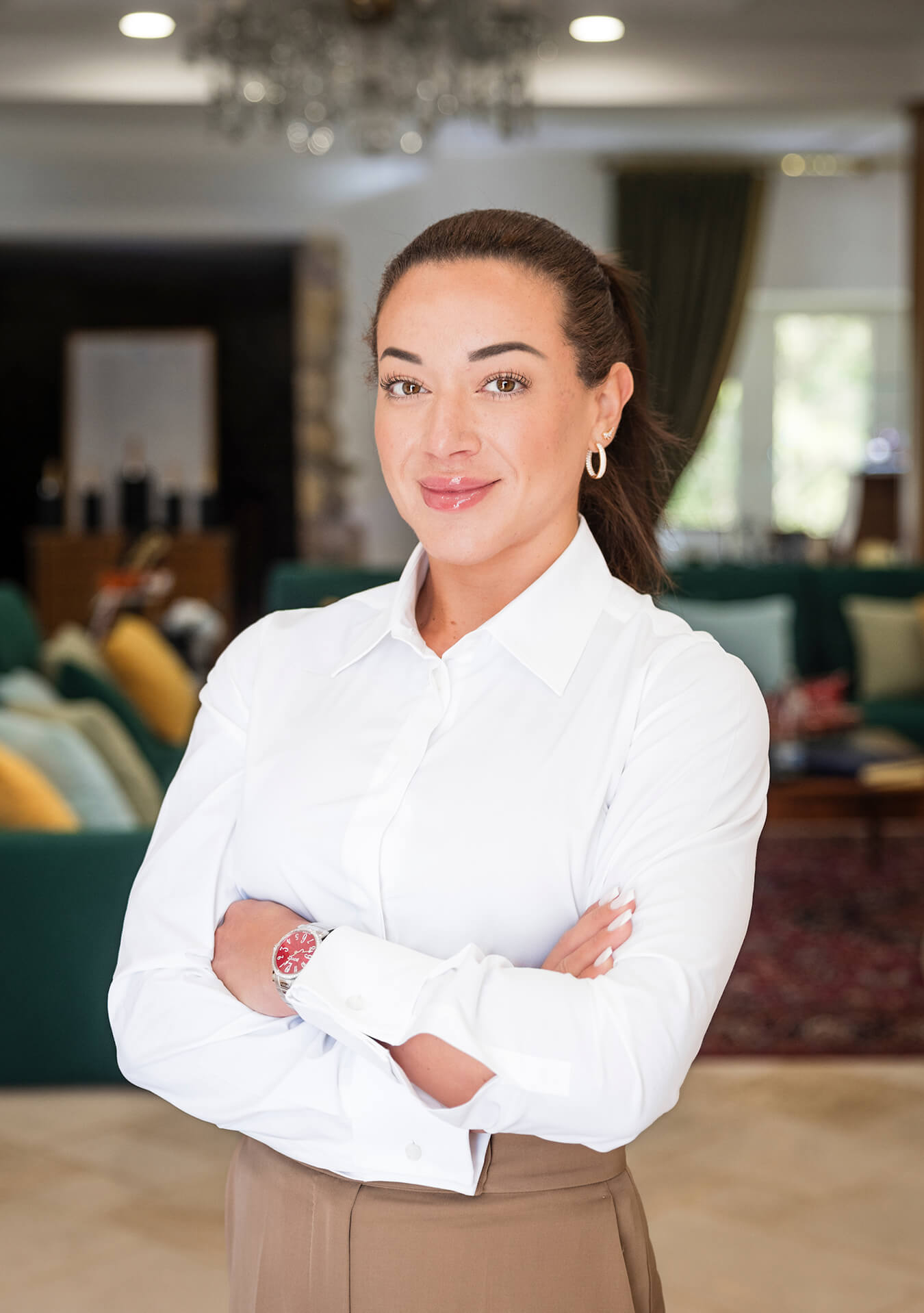 Elegant woman wearing a Bovet timepiece, standing confidently in a luxurious, well-lit interior sett.