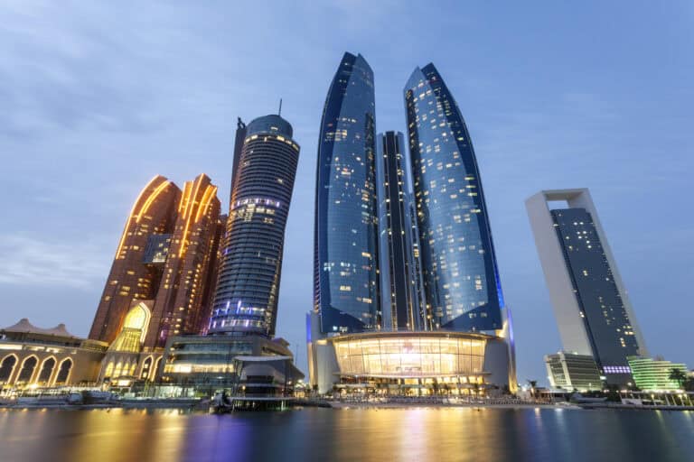 Modern Dubai skyline with illuminated skyscrapers and Marina waterfront at dusk.