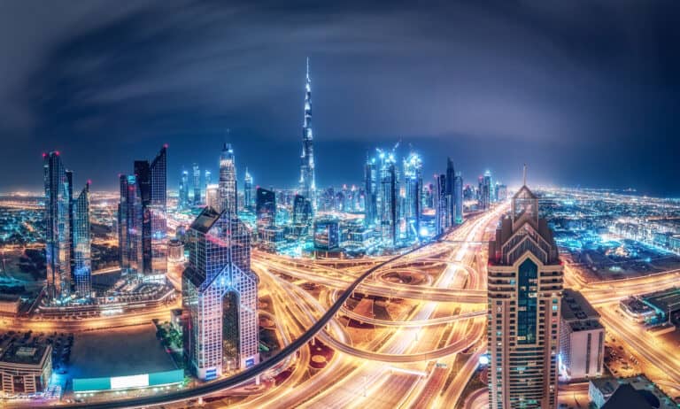 A stunning nighttime view of Dubai's skyline featuring illuminated skyscrapers and vibrant city ligh.