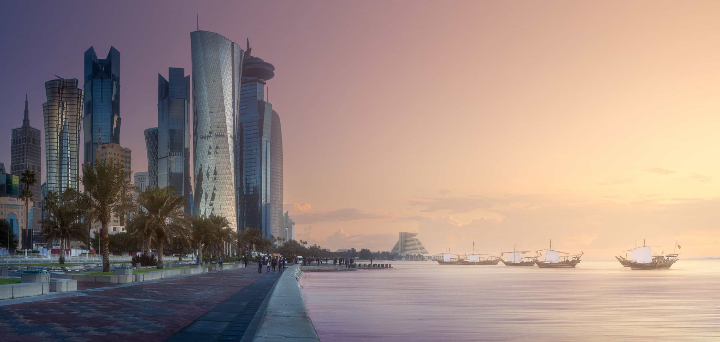 Elegant city skyline featuring modern skyscrapers along a waterfront at sunset, highlighting luxury.