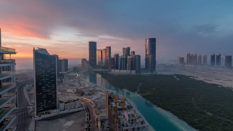 Elegant skyline of Dubai with modern skyscrapers and a serene waterway at sunset, highlighting luxur.