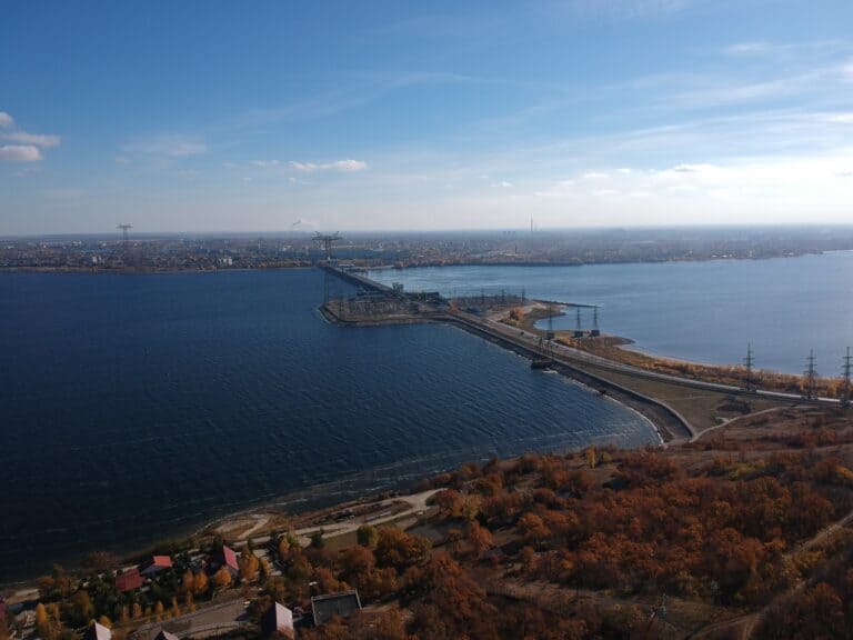 Scenic view of a harbor with a bridge and city skyline under a clear blue sky.
