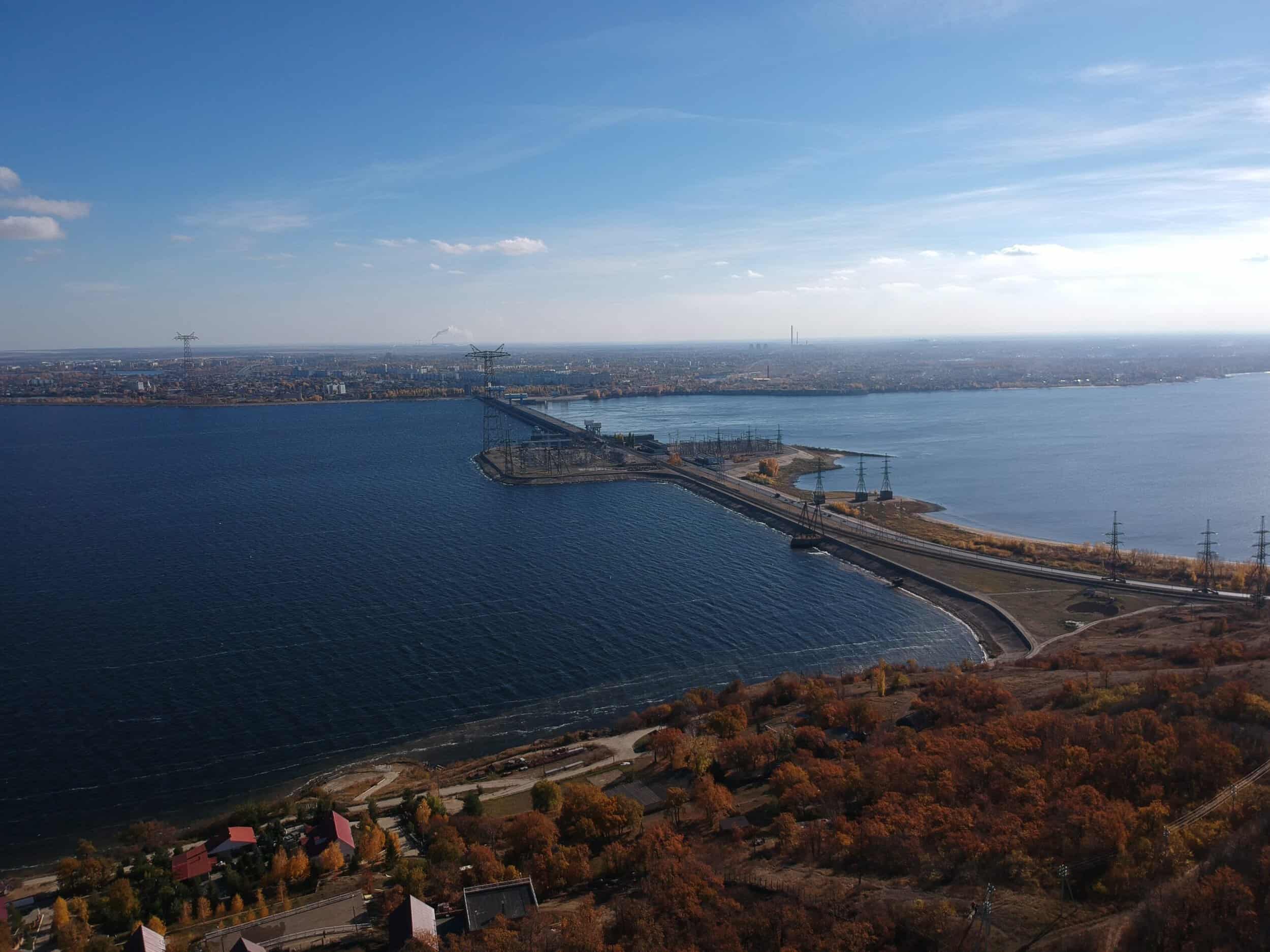 Scenic view of a harbor with a bridge and city skyline under a clear blue sky.