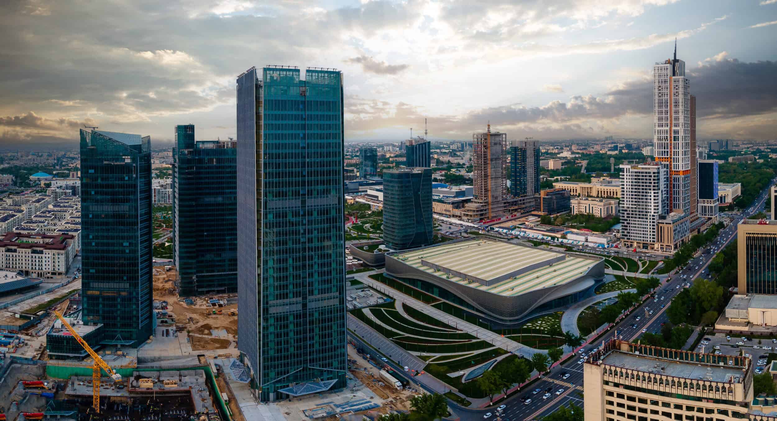 Modern cityscape with skyscrapers and a sports arena, highlighting luxury timepieces in an urban set.