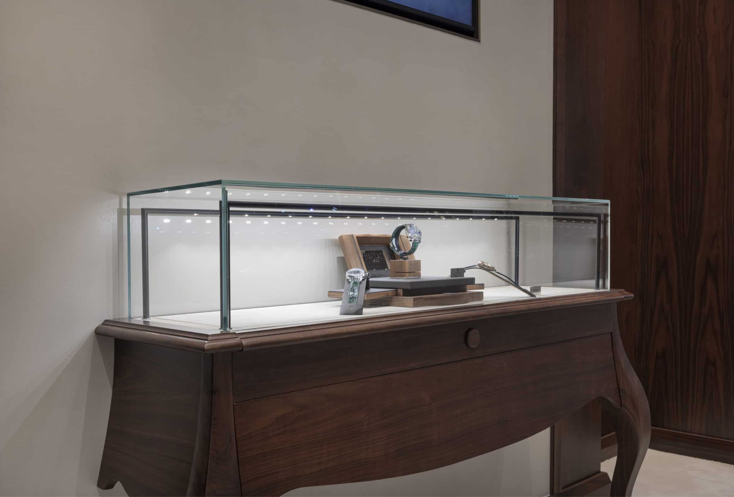 Elegant Bovet timepieces displayed in a glass case on a wooden table, highlighting craftsmanship and.