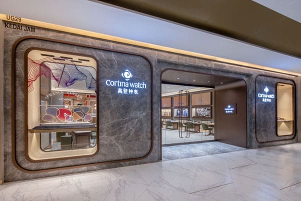 Elegant storefront of Cortina Watch at The Starhill, showcasing luxury timepieces in a modern, sophi.