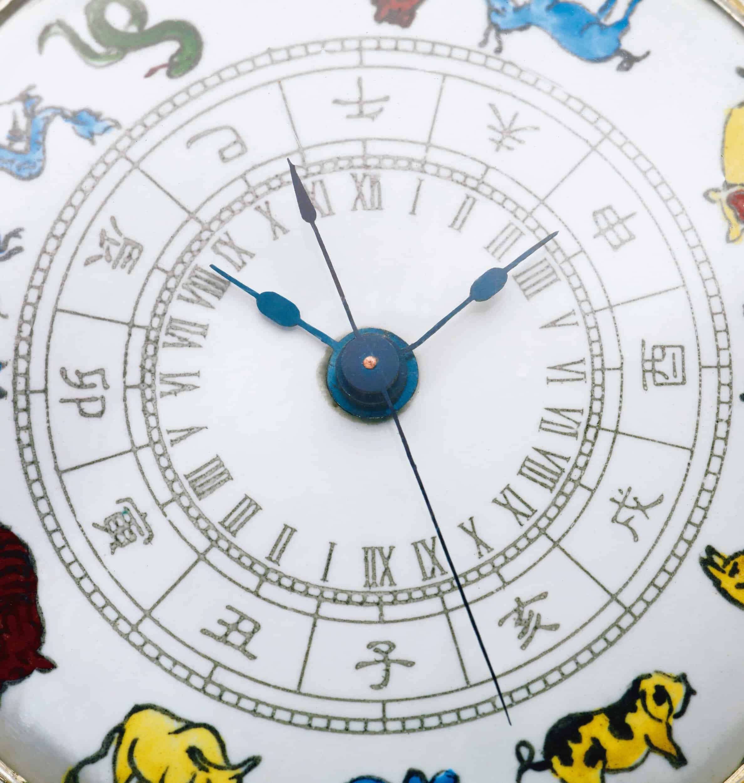 Intricate clock face with zodiac symbols and Roman numerals on a Bovet timepiece.