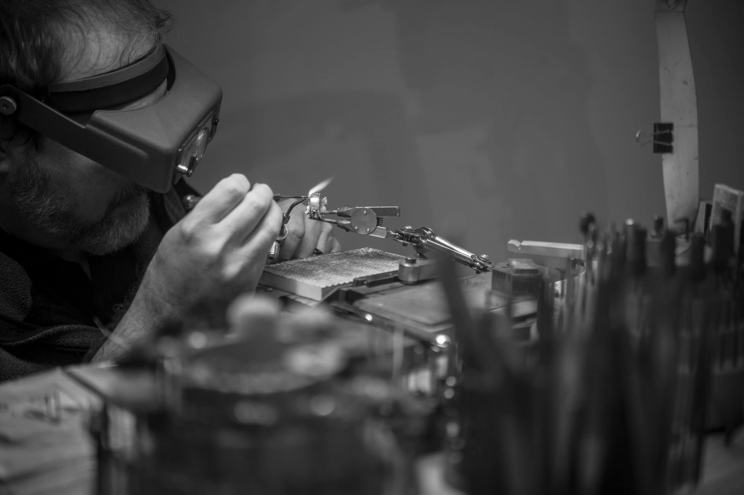 Expert craftsman assembling a luxury timepiece in a workshop setting.