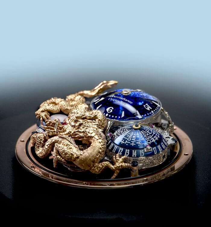 Luxurious blue timepiece with intricate gold serpent detail on a sleek black surface.