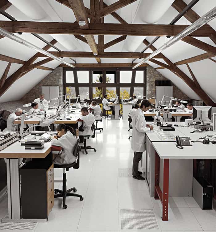 High-tech manufacturing workshop with artisans assembling intricate timepieces in a spacious, well-l.